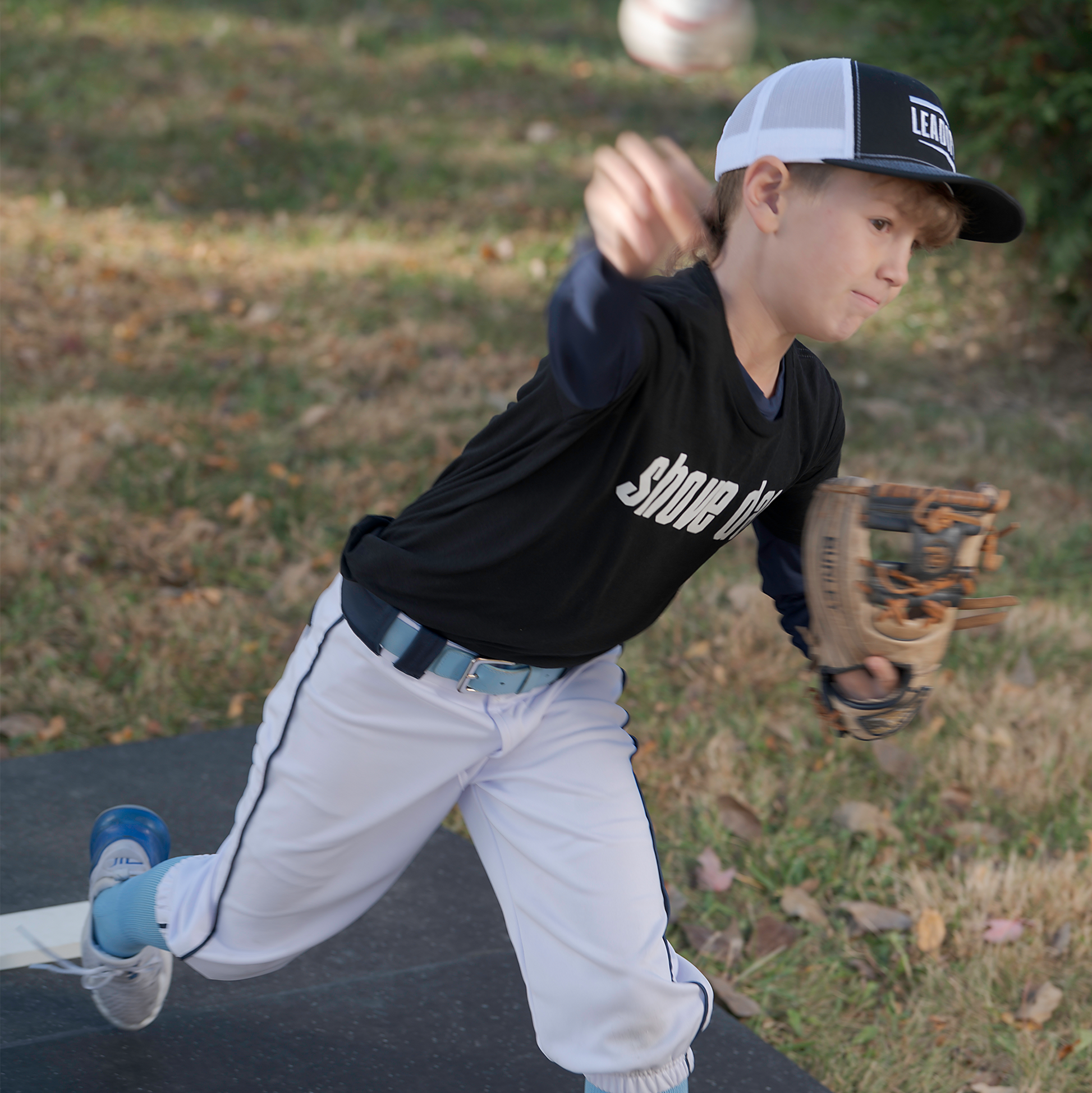 Athlete pitching off a FirstStrike Wheeled 6-Inch portable Pitching Mound.