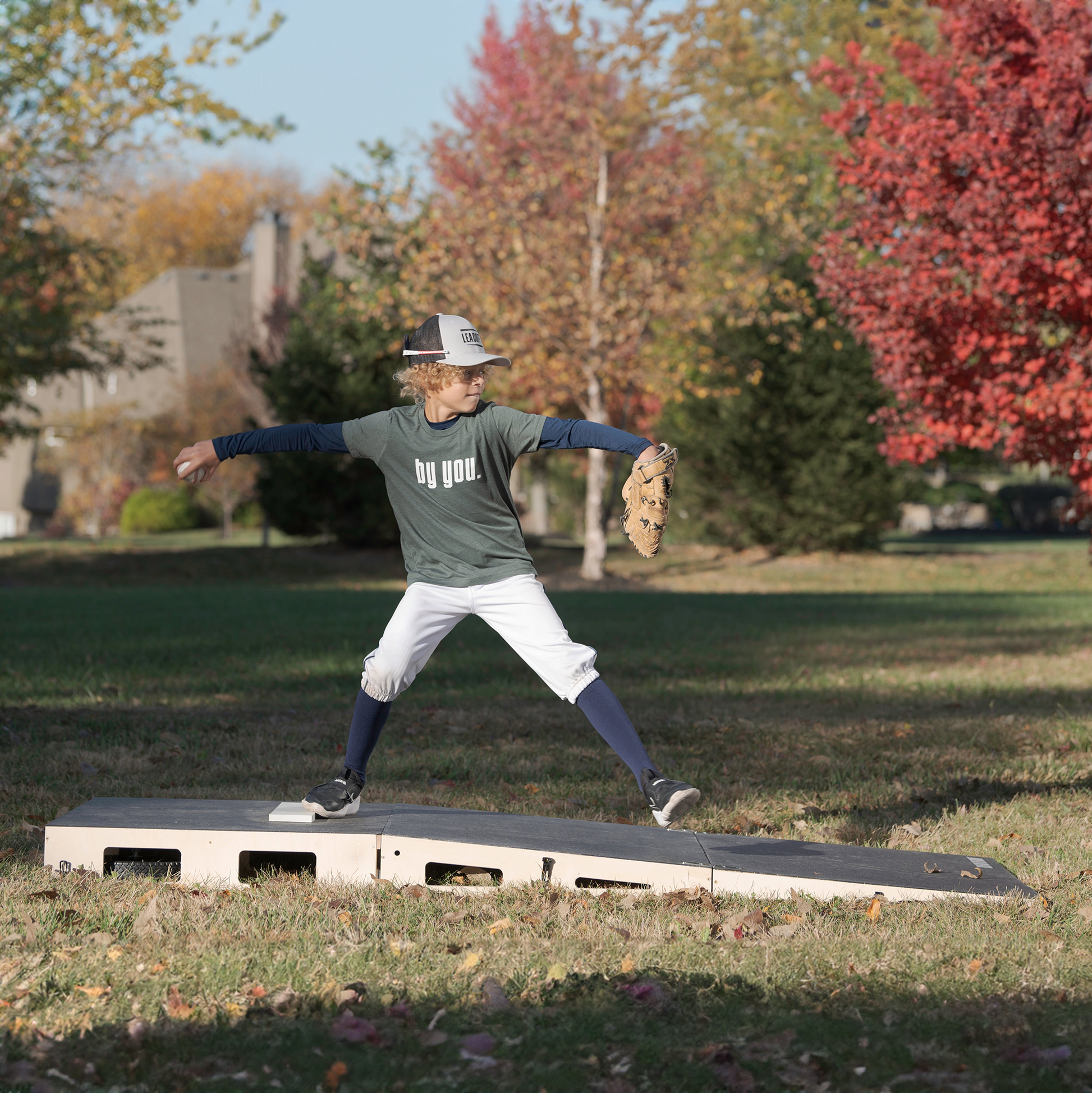 Young pitcher practicing on the FirstStrike Wheeled 6-Inch portable Pitching Mound in a park.